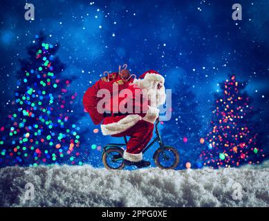 Santaclaus fait du vélo pour offrir des cadeaux de noël rapides Banque D'Images