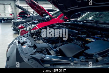 Atelier de réparation automobile. Les voitures ouvrent le capot garé dans le garage pour le service de réparation et d'entretien. Enregistrement de voiture à la station-service. Voiture en attente d'inspection dans l'atelier de réparation automobile. Entretien du véhicule et liste de contrôle. Banque D'Images