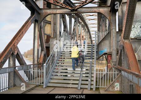Piétons traversant le pont de remontée délabré au-dessus de l'Elbe près de Magdeburg Banque D'Images