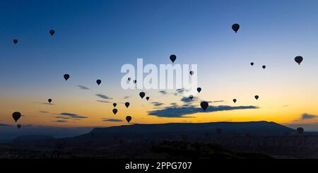 les montgolfières décollent au lever du soleil au-dessus de la ville de goreme Banque D'Images