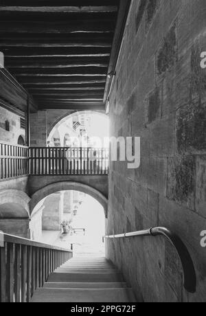 Plan noir et blanc de l'escalier descendant avec balustrade en bois à un ancien bâtiment historique abandonné Banque D'Images