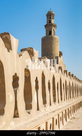 Briques de pierre ancienne clôture décorée de la mosquée Ibn Tulun et minaret de la mosquée, le Caire, Egypte Banque D'Images