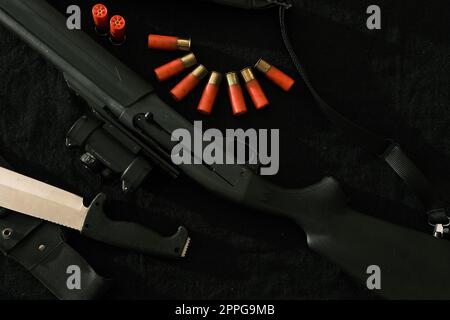 Arme sur tissu noir : couteau, fusil, obus, vue de dessus. Vue de dessus de couteau, fusil, obus. Banque D'Images