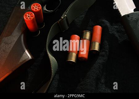 Arme sur tissu noir : couteau, fusil, obus, vue de dessus. Vue de dessus de couteau, fusil, obus. Banque D'Images