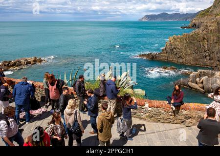 Un groupe de touristes sur la terrasse dans un petit village au bord de la mer Ligurienne, Riomaggiore, Cinque Terre, Italie Banque D'Images