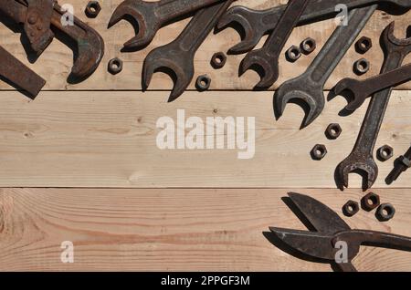Un ensemble d'outils anciens et rouillés repose sur une table en bois dans l'atelier Banque D'Images