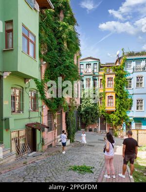 Vieilles maisons colorées traditionnelles dans le quartier de Balat, avec des touristes prenant des photos commémoratives sur un été, Istanbul, Turquie Banque D'Images