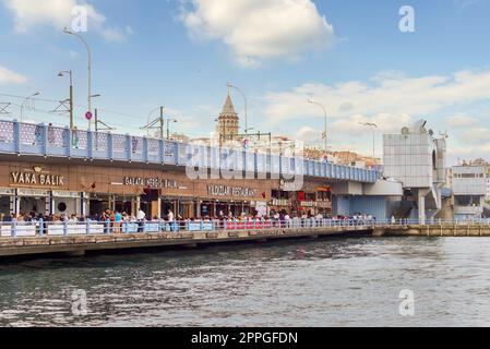 Restaurants de poissons au pont bondé de Galata, pendant le jour de la victoire avec la Tour de Galata dans le Far End, Istanbul, Turquie Banque D'Images