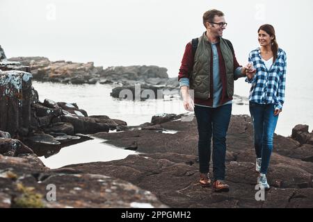 Cette date va vraiment bien. un couple heureux de randonnée main dans la main. Banque D'Images