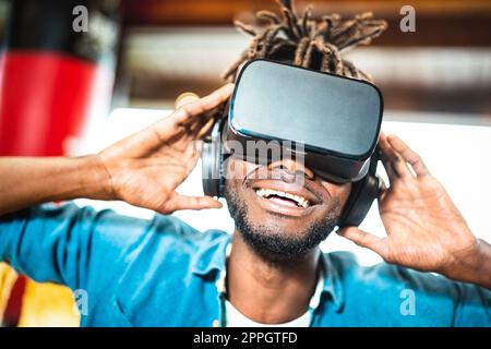 Jeune afro-américain expérimentant le jeu de lunettes vr - réalité virtuelle et concept de technologie wearable avec homme heureux s'amuser avec des lunettes de casque - G Banque D'Images