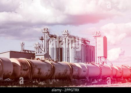 Le chemin de fer traverse la zone industrielle avec un silo à grains Banque D'Images