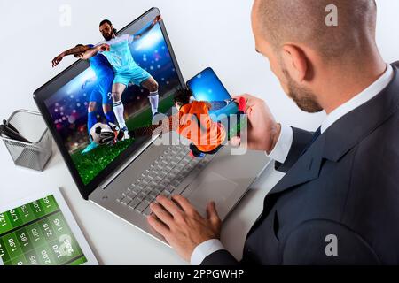 Homme d'affaires regarde le match de football et parie sur le site Web de football Banque D'Images