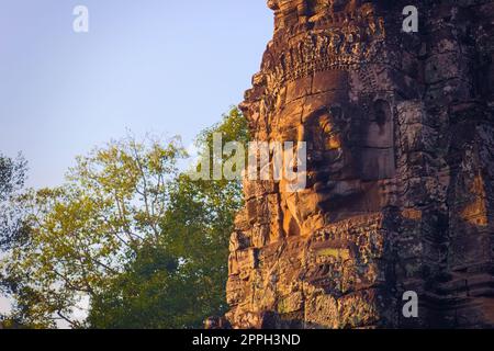 Face en pierre cambodgienne au temple de Bayon, situé à Angkor, au Cambodge, ancienne capitale de l'empire khmer. Banque D'Images