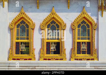 Temple de Wat Benchamabophit, situé à Bangkok, Thaïlande. Détail architectural des fenêtres dorées ornées. Banque D'Images