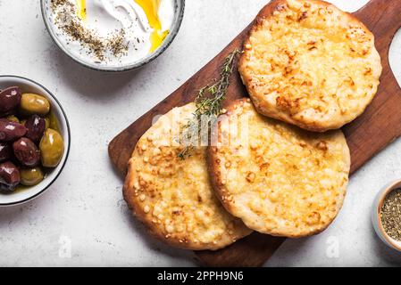 Manakeesh, pizza arabe, pain plat recouvert de fromage et zaatar labneh pour le petit déjeuner. Manakish à pain plat méditerranéen maison de près. Arabe t Banque D'Images