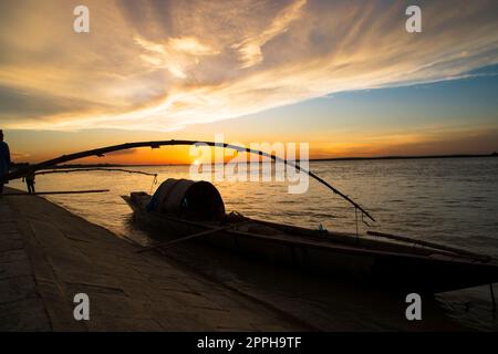 Un bateau en bois sur la mer contre le ciel pendant le coucher du soleil Banque D'Images