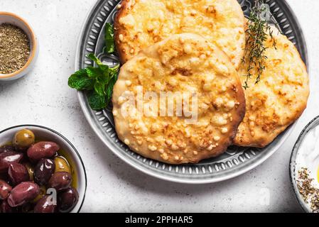 Manakeesh, pizza arabe, pain plat recouvert de fromage pour le petit déjeuner. Manakish à pain plat méditerranéen maison de près. Cuisine arabe. Banque D'Images