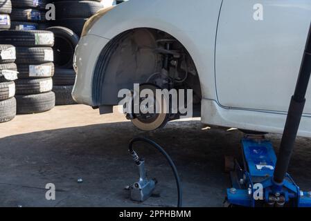 Changer un pneu de voiture causé par un pneu crevé en utilisant un cric pour soulever la voiture. Banque D'Images