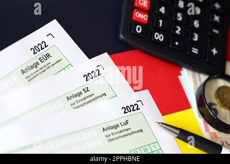 Différents formulaires vierges de déclaration fiscale allemands - Anlage EUR, Anlage SZ et Anlage LUF. Les documents se trouvent avec la calculatrice, le stylo et l'argent européen Banque D'Images