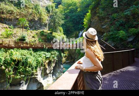 Jeune femme marchant sur le chemin dans le paysage sauvage appréciant avec des cascades et les gorges d'un canyon naturel Banque D'Images