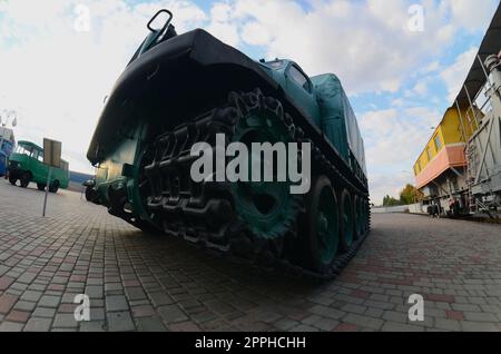 Photo d'une voiture blindée vert russe sur une voie caterpillar parmi les trains de chemin de fer. Une forte distorsion de l'objectif fisheye Banque D'Images