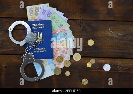 Une photographie d'un passeport ukrainien étranger, une certaine quantité d'argent ukrainien et des menottes de police. L'idée d'arrêter les immigrants illégaux ukrainiens tout en essayant de soudoyer Banque D'Images