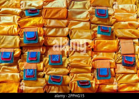 Gros plan d'une pile de livres de prière enveloppés de nappes orange dans un monastère bouddhiste en Mongolie, en Asie centrale. Banque D'Images