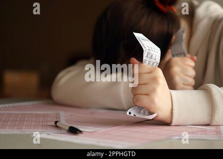 Une jeune fille triste souffre d'une perte après avoir regardé le résultat malchanceux du jeu de loterie. Le concept de perdre la loterie et dépenser de l'argent Banque D'Images