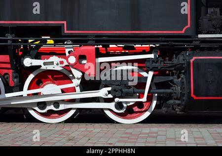 Roues de la vieille locomotive à vapeur noir de l'époque soviétique. Le côté de la locomotive avec les éléments de la technologie rotative de vieux trains Banque D'Images