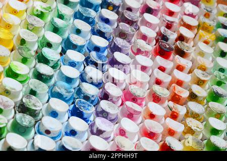 Un motif d'un grand nombre de buses d'un pulvérisateur de peinture pour dessiner des graffitis, tachés dans différentes couleurs. Les capuchons en plastique sont disposés en plusieurs rangées formant la couleur de l'arc-en-ciel Banque D'Images