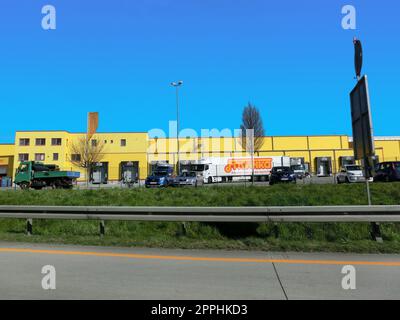 Friweika - vue d'un parc logistique avec entrepôt, plate-forme de chargement et semi-camions avec remorques de fret debout sur les rampes pour charger, décharger des marchandises. Banque D'Images