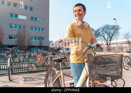 Une femme prend un vélo loué dans un parking à vélos Banque D'Images