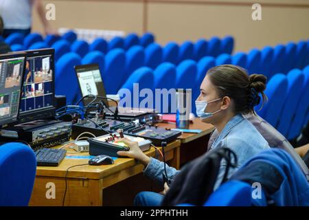 Jeune femme éditeur vidéo dans masque de protection travaillant sur la conférence, séminaire, utiliser l'ordinateur portable de montage vidéo pour la diffusion sur Internet, les médias sociaux Banque D'Images