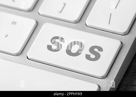Bouton avec mot SOS sur le clavier de l'ordinateur, gros plan. Concept de sauvetage Banque D'Images
