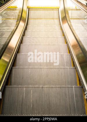 Vue de dessus des escaliers mécaniques, lumière du soleil de l'extérieur Banque D'Images