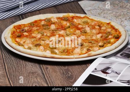 Pizza avec saumon et olives sur table en bois Banque D'Images