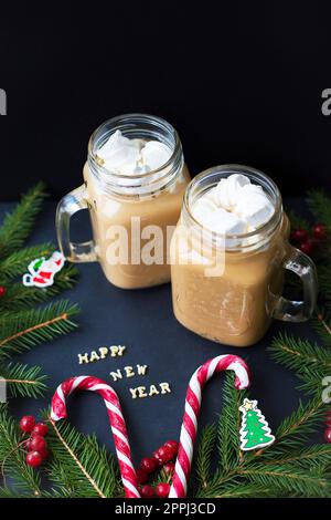 Marshmellou cacao, ornements d'arbre de Noël et bonbons sur fond noir. L'inscription bonne année Banque D'Images