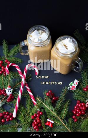 chocolat chaud et bonbons marshmellou sur le fond des arbres. L'inscription Joyeux Noël Banque D'Images