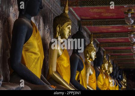 Bouddha d'or à côté de vieux murs dans les temples thaïlandais Banque D'Images