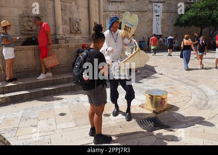 Dans les rues de Dubrovnik Croatie, les vacanciers heureux marchent et achètent des souvenirs du vendeur dans le costume national de fête croate sur 15 août, 2 Banque D'Images