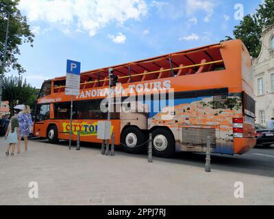 Dubrovnik, Croatie, 18 août 2022. Bus touristique orange à impériale à l'arrêt de bus. La femme et la fille sont pressés. Route et véh Banque D'Images