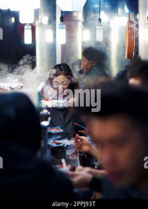 séoul, corée du sud - 11th novembre 2017 : les gourmets se trouvent dans les étals de rue de nourriture traditionnelle bondée du marché de gwangjang Banque D'Images