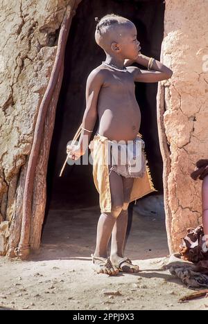 15 mai 2005. Garçon himba non identifié dans la cabane traditionnelle, Epupa Falls, Kaokoland ou province de Kunene, Namibie, Afrique Banque D'Images