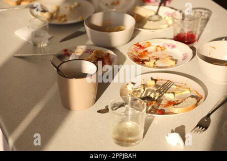 Videz les assiettes sales avec des cuillères et des fourchettes sur la table après le repas. Concept de fin de banquet. Vaisselle non lavée Banque D'Images