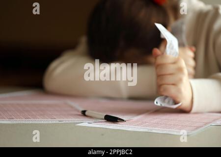 Une jeune fille triste souffre d'une perte après avoir regardé le résultat malchanceux du jeu de loterie. Le concept de perdre la loterie et dépenser de l'argent Banque D'Images