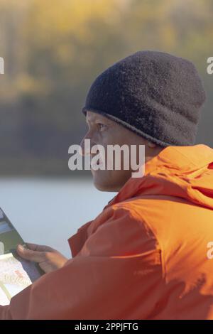 Portrait de voyageur homme au lac en automne avec une carte Banque D'Images