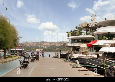 Piétons marchant le long du Bosphore entre les districts de Bebek et Hisari, et embarquant des bateaux et des yachts à Istanbul, Turquie Banque D'Images