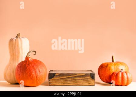 Citrouilles et podium en bois sur fond beige, espace de copie. Vitrine de produits tendance de saison. Halloween ou Thanksgiving concept de célébration. Banque D'Images