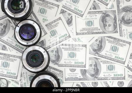 Quelques verres photographiques se trouvent sur le fond d'un grand nombre de billets de dollars. Espace pour le texte Banque D'Images