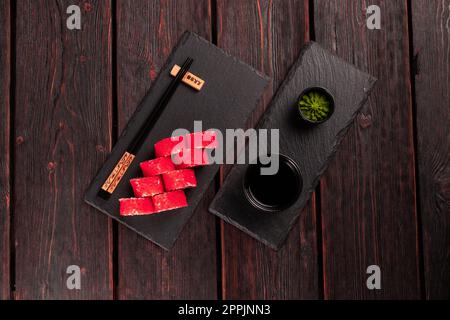 Roul de sushi californien avec saumon, concombre d'avocat et caviar de tobiko servi sur tableau noir avec vue sur le dessus - cuisine japonaise Banque D'Images